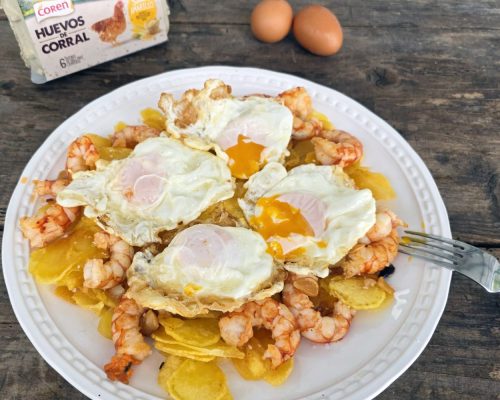 Plato de huevos rotos con langostinos