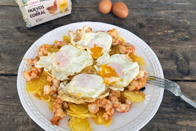 Plato de huevos rotos con langostinos