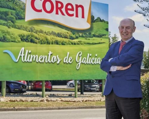 Manuel Gómez-Franqueira, presidente del Grupo Coren, ante el cartel de Alimentos de Galicia en la sede de la cooperativa